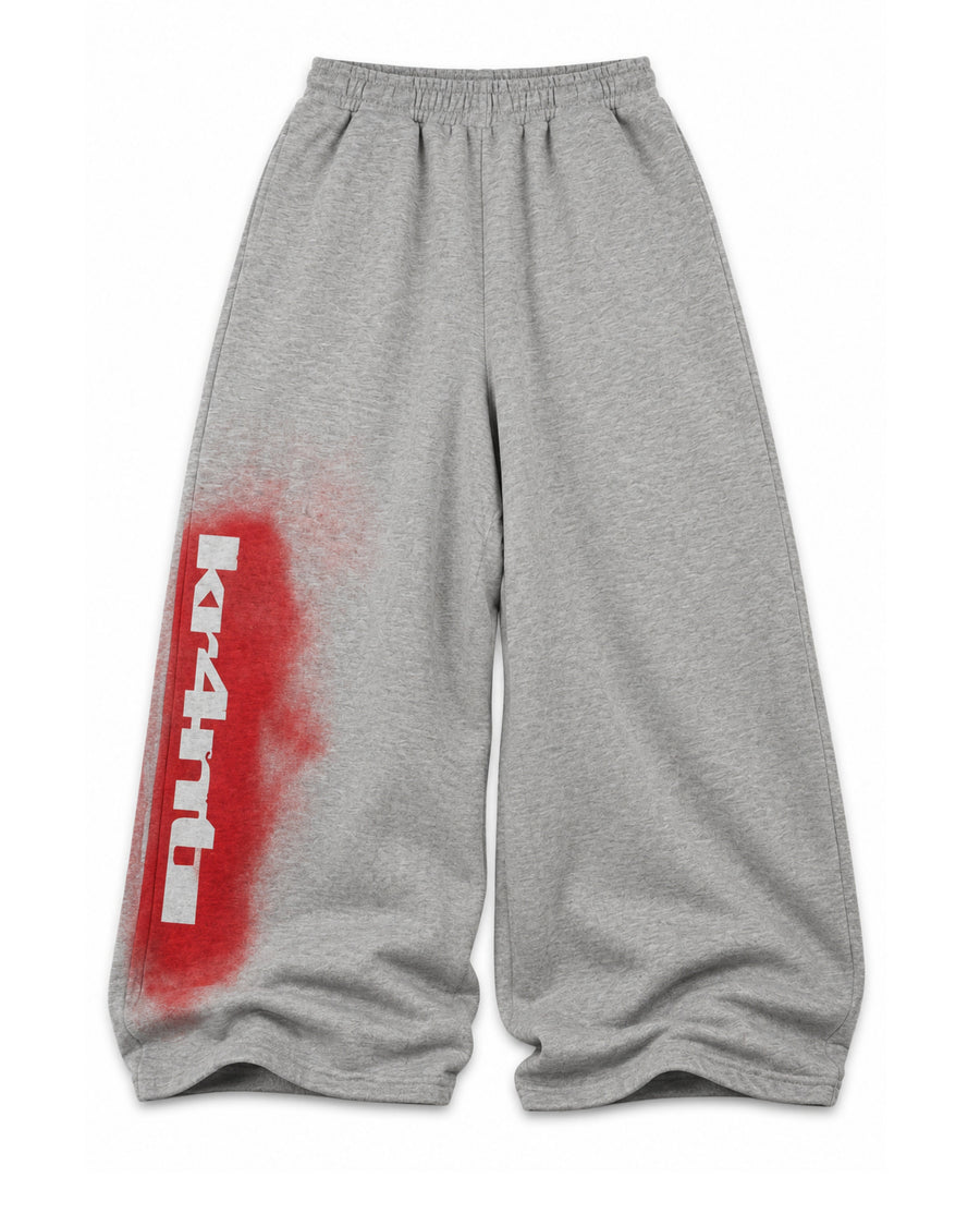 Grey baggy SPRAY-PAINT STENCIL SWEATS with a red spray-painted kr4nti stencil down the left leg